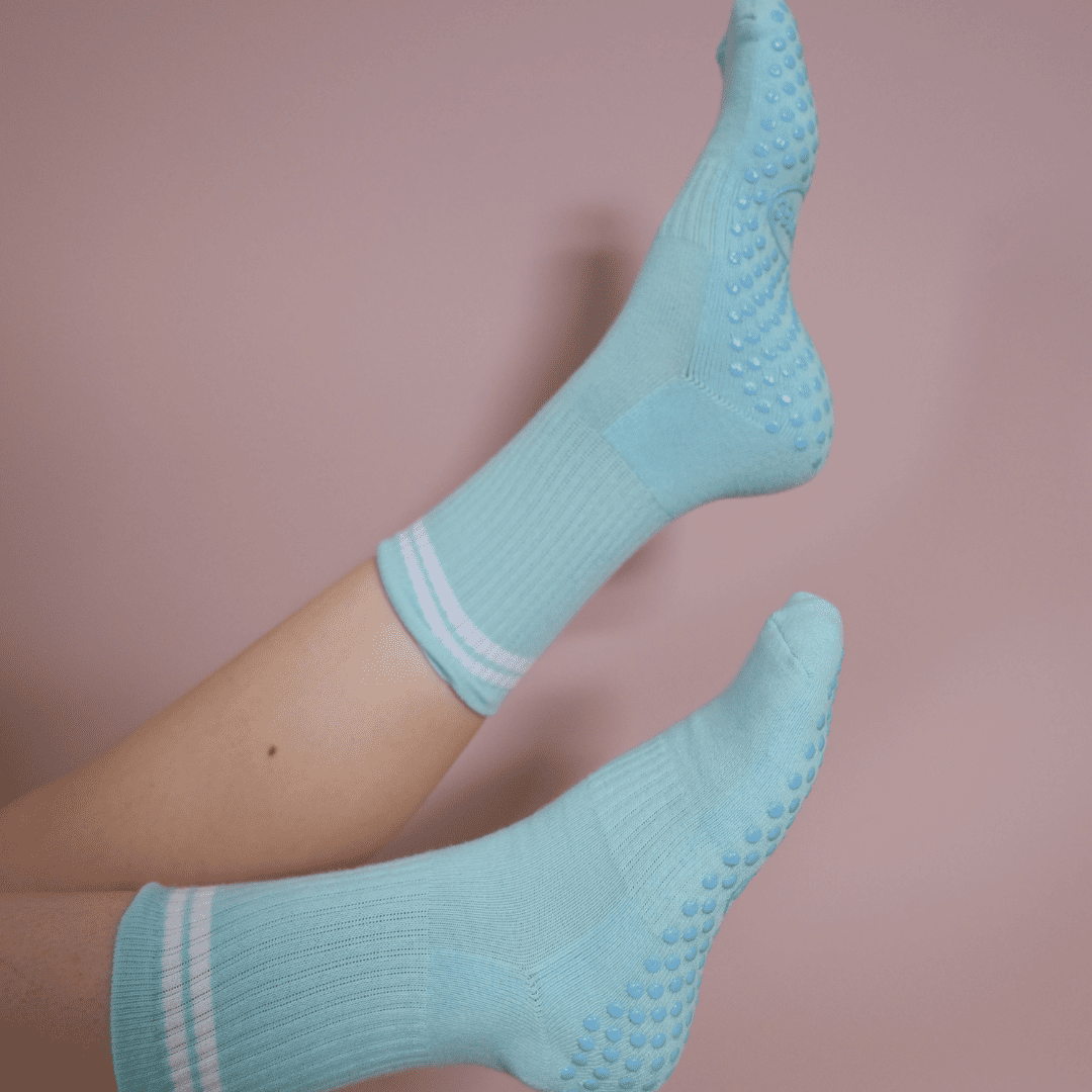 Blue and white GRIPTEC pilates grip socks worn on the mat