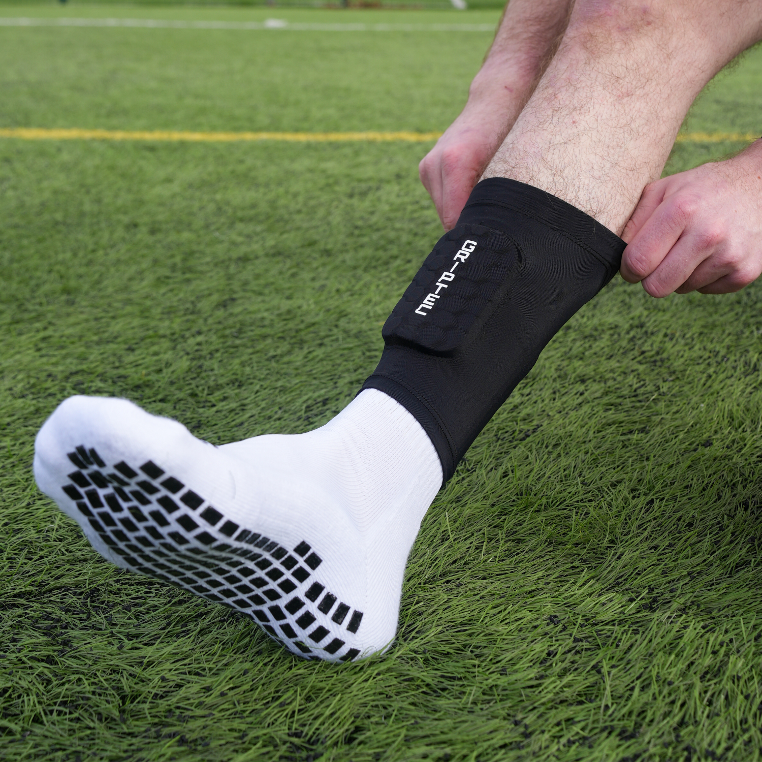 GRIPTEC grip socks worn with black shin pad sleeves during football training