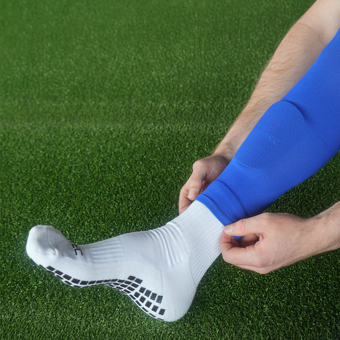 Close-up of GRIPTEC mini shin pads worn under a sock sleeve with grip socks
