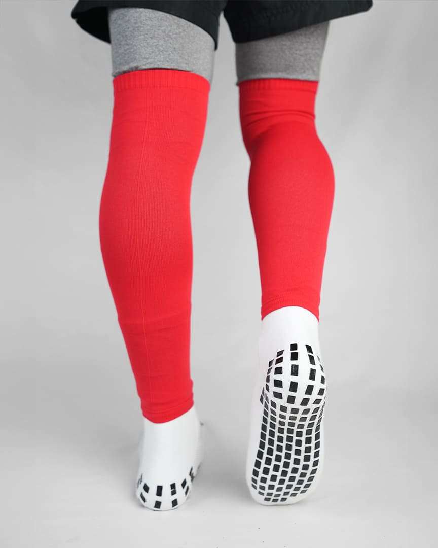 Player wearing red GRIPTEC sock sleeves over white grip socks